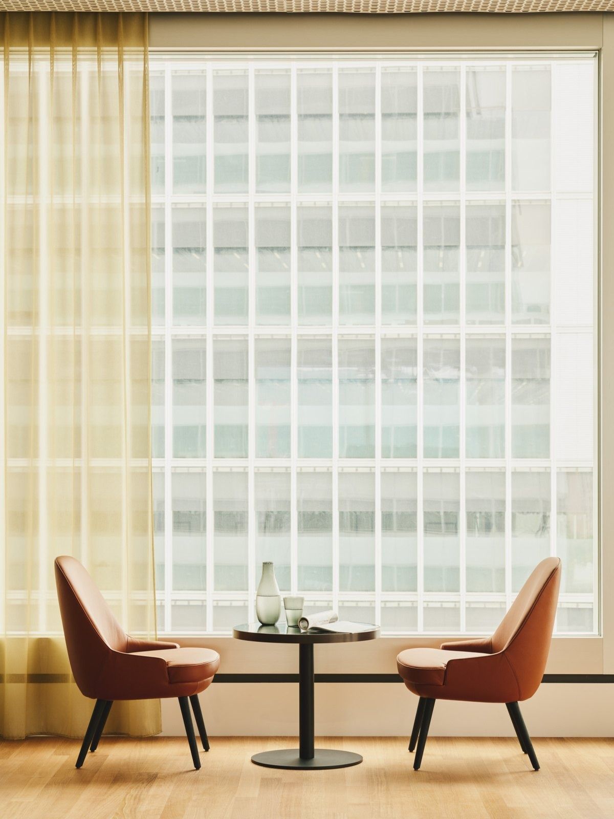 Roche: Two armchairs and a small table by a tall window