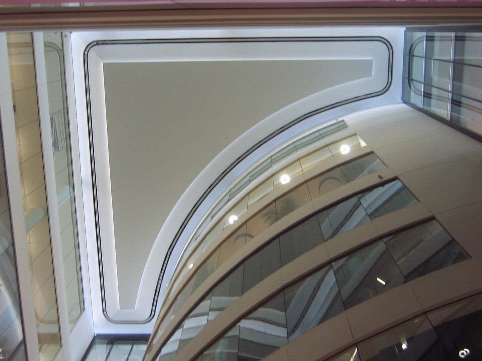 Rolls-Royce: Looking up at curved white balconies and a ceiling inside an atrium