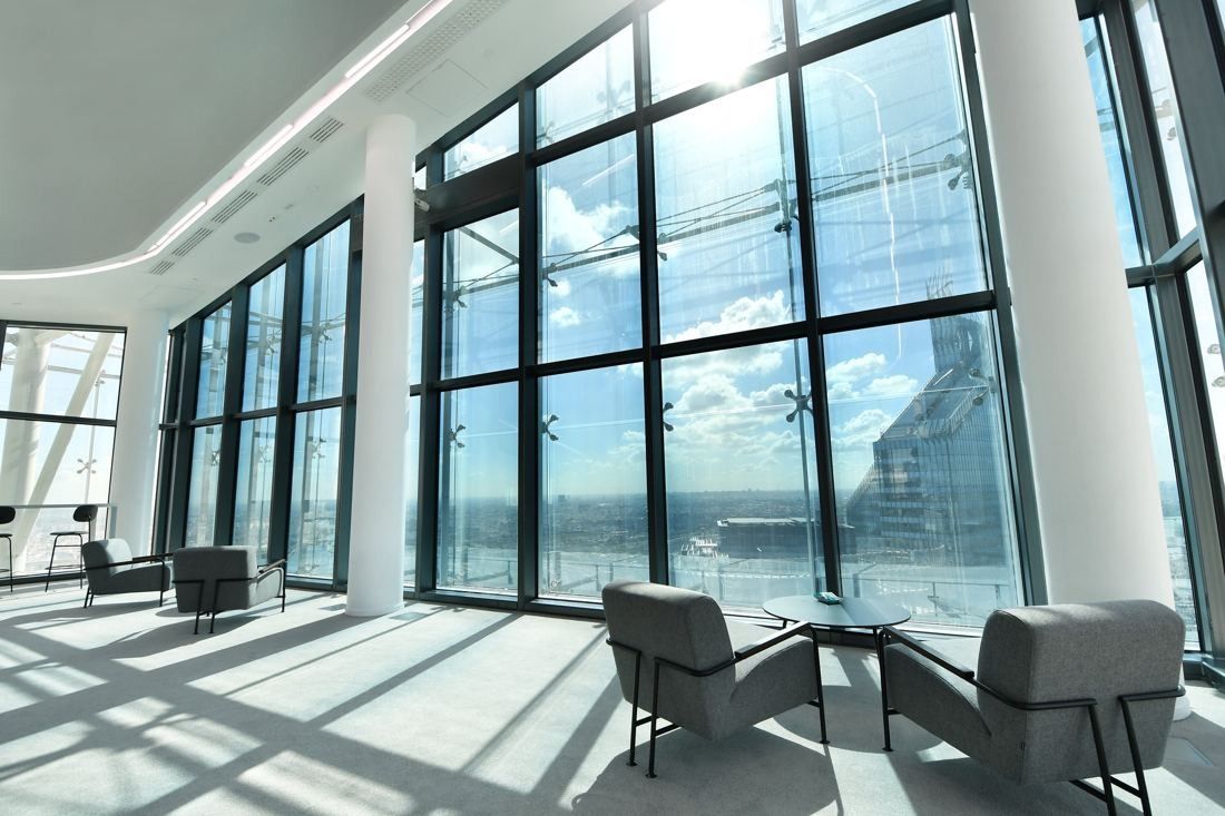 Saint-Gobain: Armchairs beside tall windows with sunlight falling across the floor