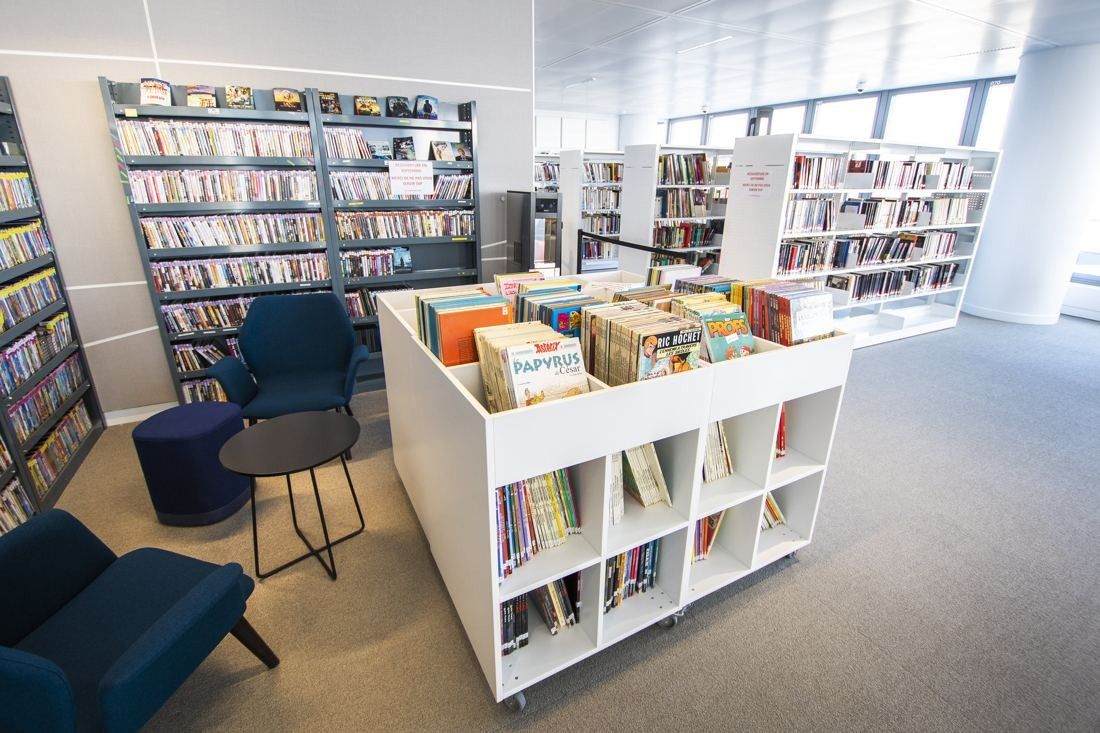 Saint-Gobain: Bookshelves and low book bins with blue armchairs