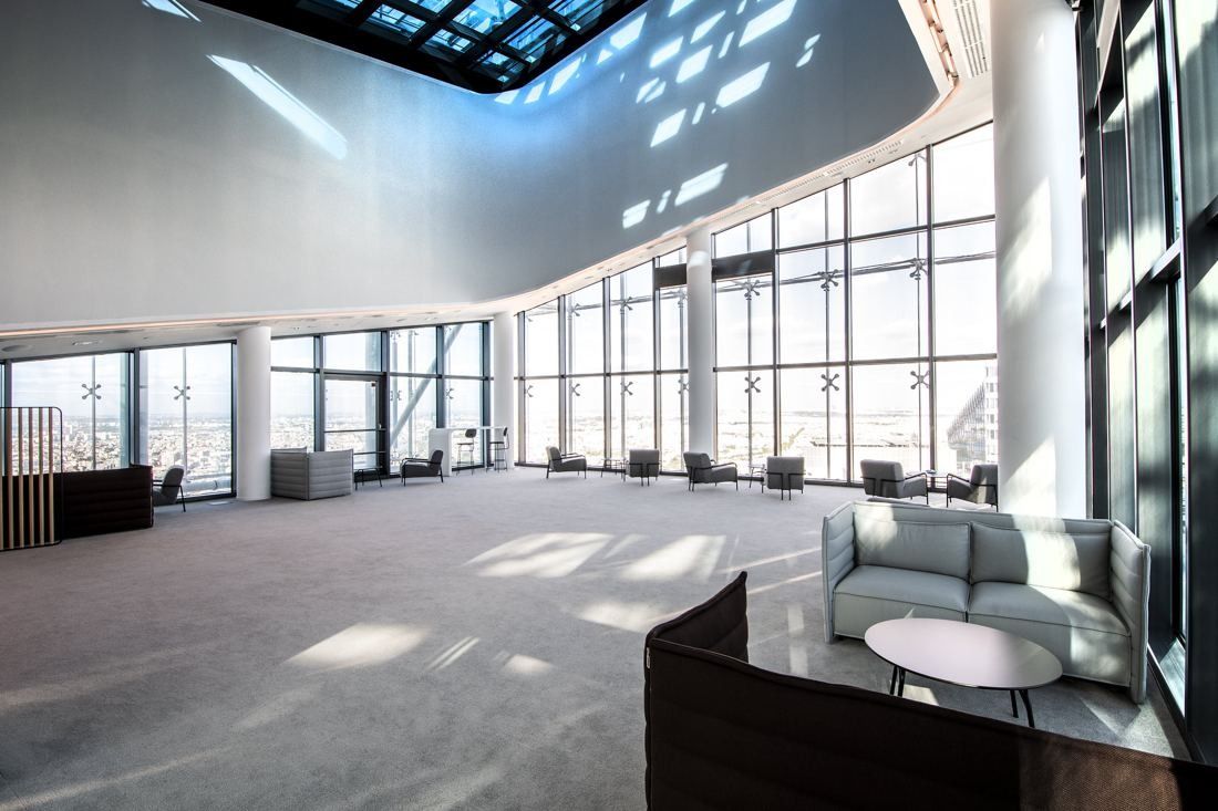 Saint-Gobain: Open space with armchairs and full-height windows under a skylight