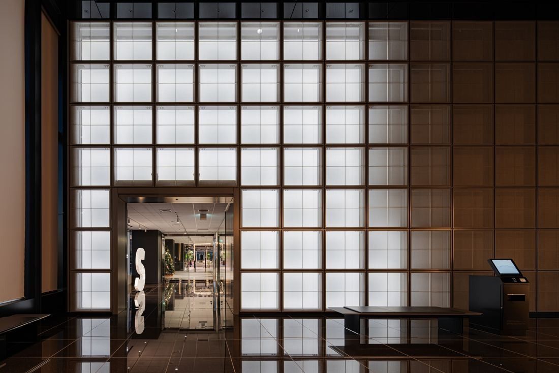 Sansan: Entrance with a wooden lattice wall of glass panes and a doorway marked with a large S