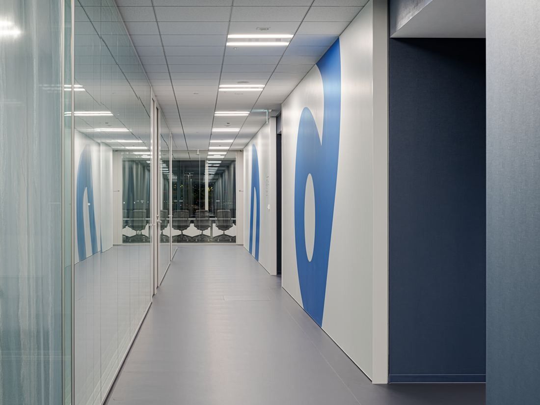 Sansan: Long corridor with blue and white graphic walls and glass doors
