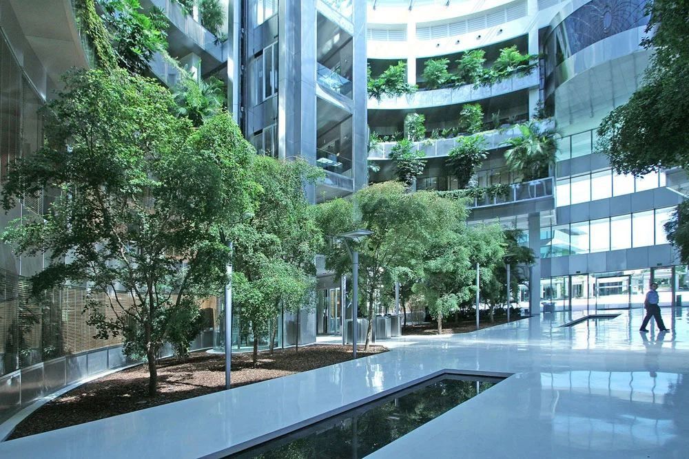 Banco Santander: Bright glazed atrium with trees in planters and a long water channel