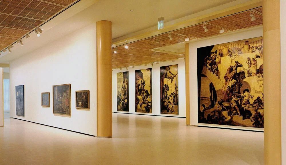 Banco Santander: Gallery with timber pillars and large paintings on white walls