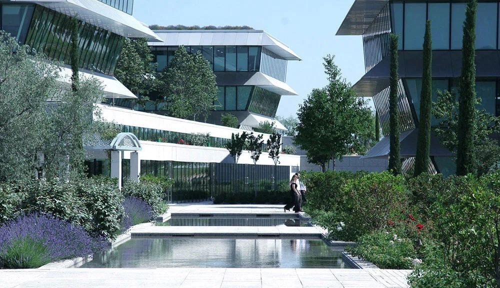 Banco Santander: Garden with lavender, cypresses and a shallow pool between office buildings