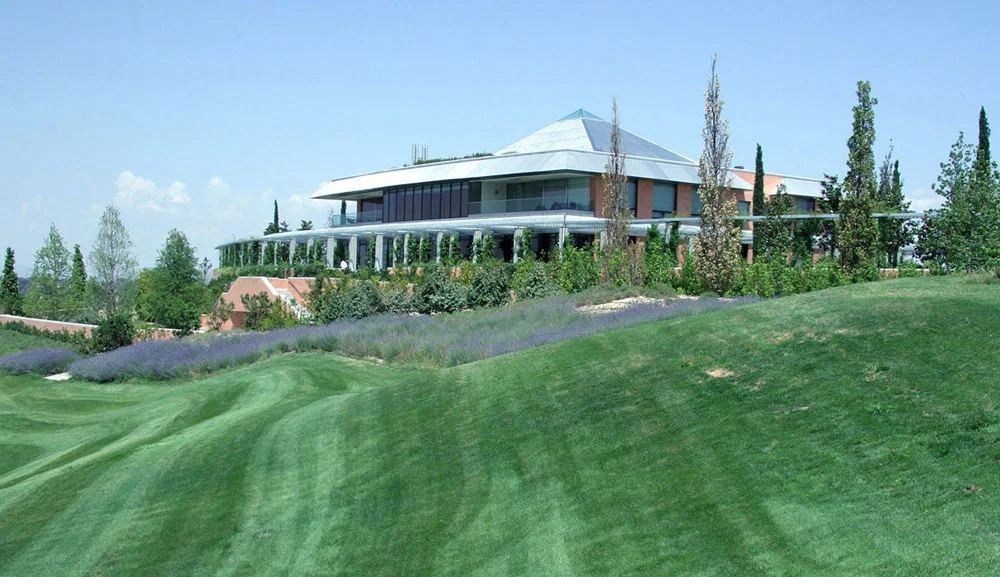 Banco Santander: Sloping lawn and lavender in front of a low building with a hipped roof