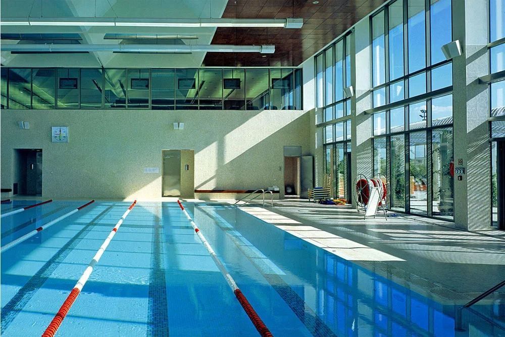Banco Santander: Sunlit indoor pool with lane ropes and a full-height glass wall