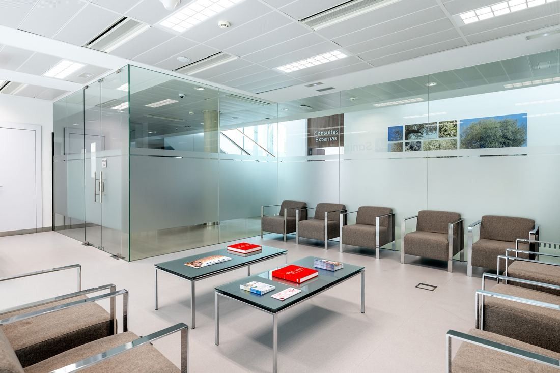 Banco Santander: Waiting area with grey armchairs and glass-walled rooms