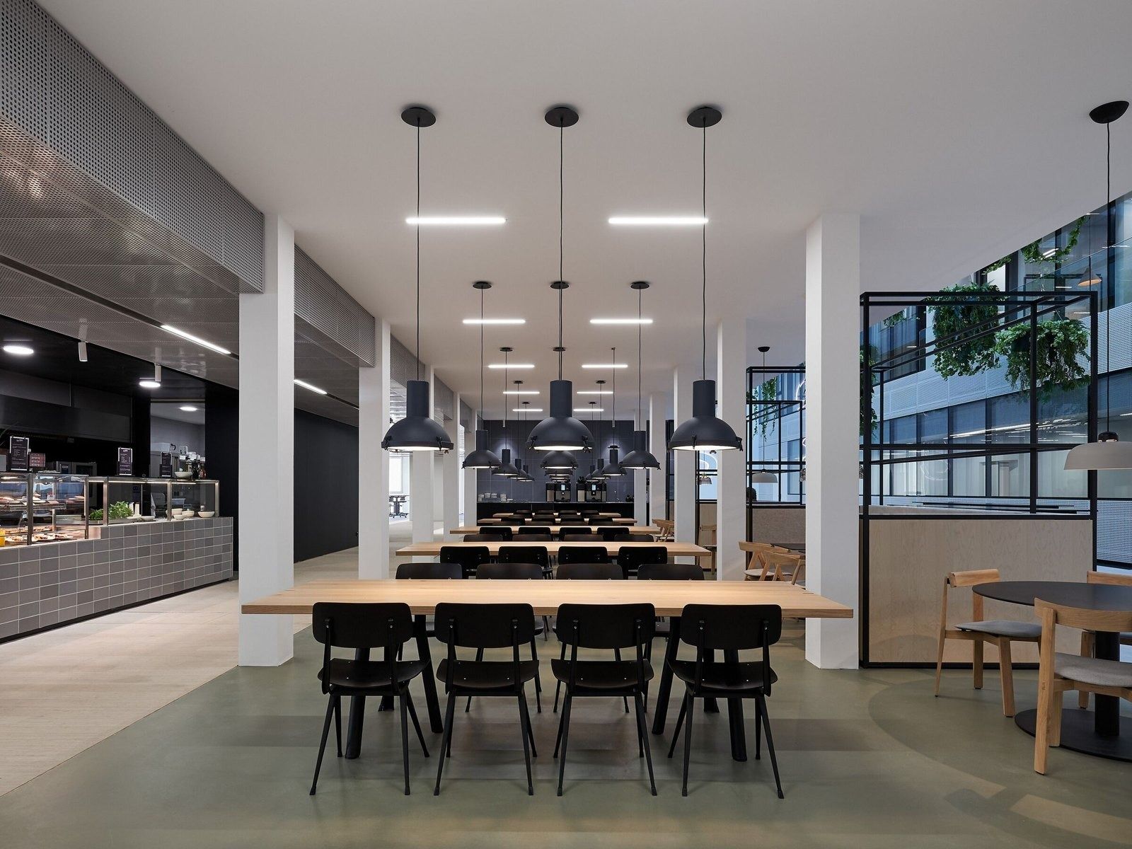 SAP: A canteen with long wooden tables and black pendant lamps