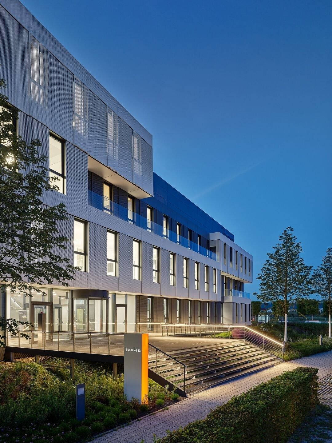 SAP: An office building with stepped facades lit at dusk