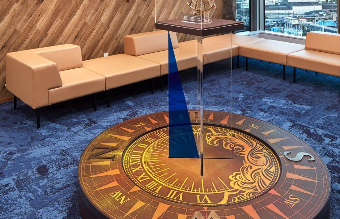 SEGA: Close view of a compass-rose table with a blue pointer in a lounge