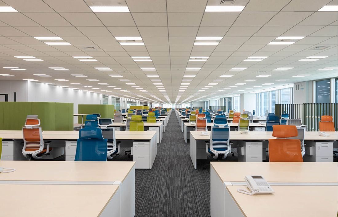 SEGA: Long open office floor with rows of desks and colorful chairs