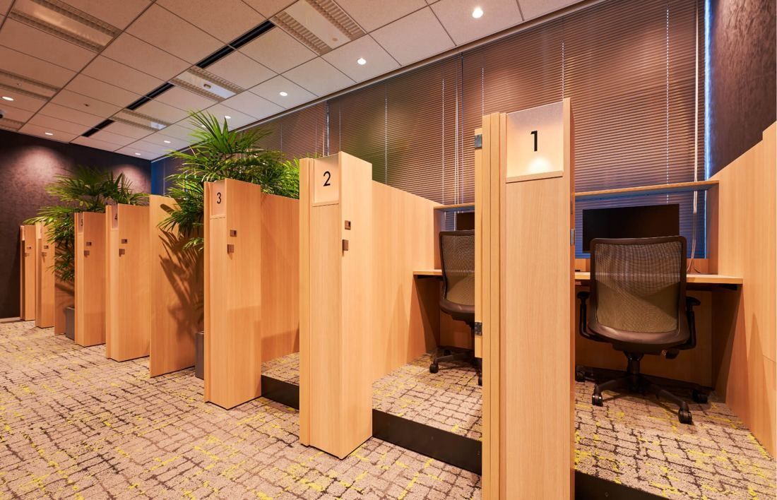 SEGA: Numbered wooden focus booths with desks and plants