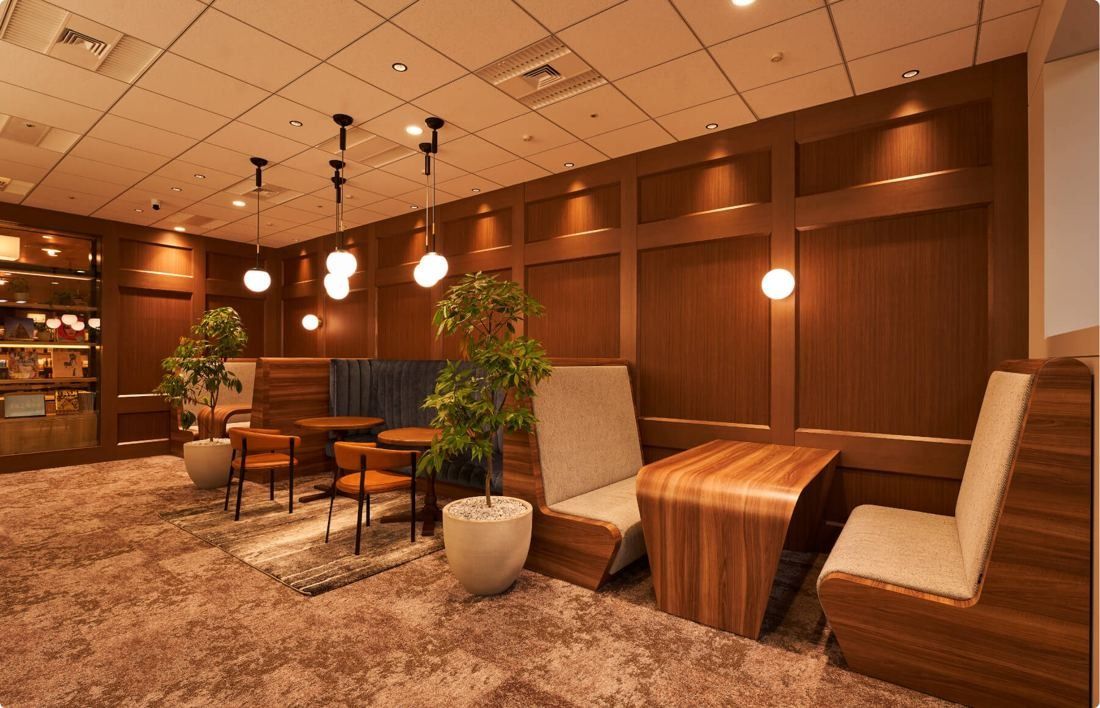 SEGA: Wood-paneled lounge with pendant lights and low armchairs