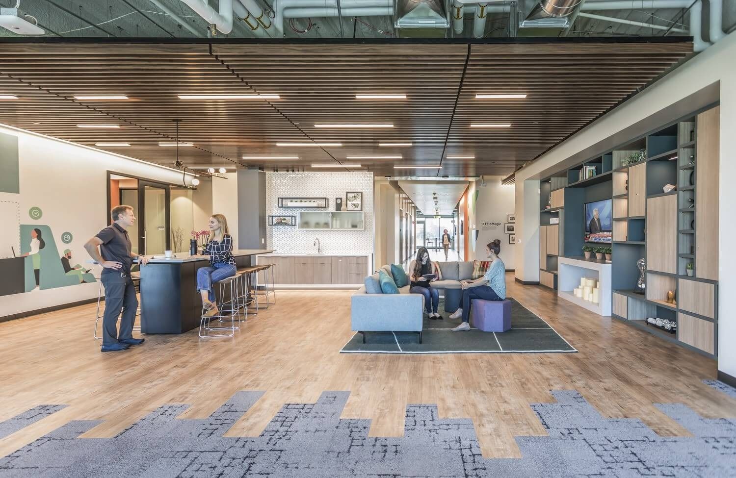 An open lounge and coffee bar with wood floors at ServiceNow Santa Clara