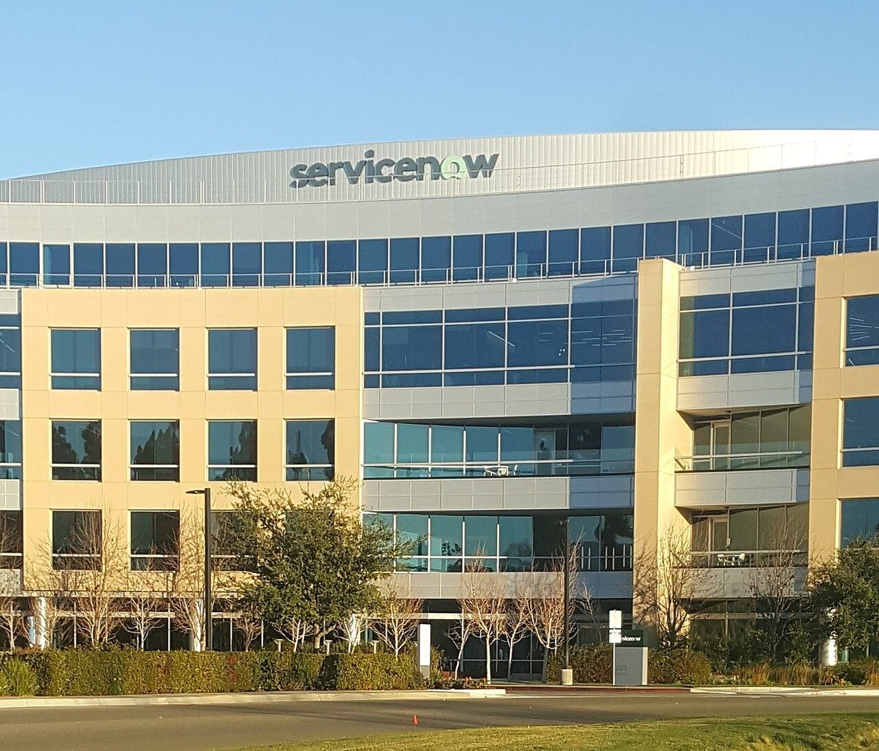 Glass and yellow office building with the ServiceNow logo