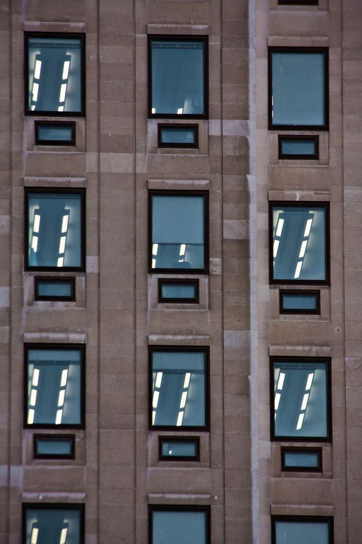 Shell: Close view of windows in the stone facade with lights on inside