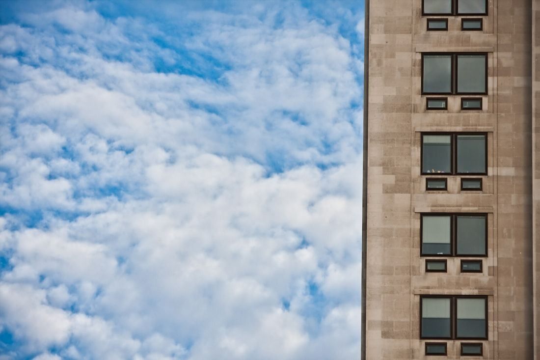 Shell: Edge of the stone tower with its windows against a sky of small white clouds
