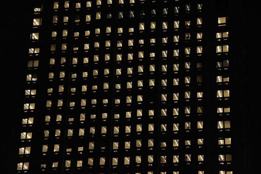 Shell: Facade at night, a grid of softly lit windows against darkness