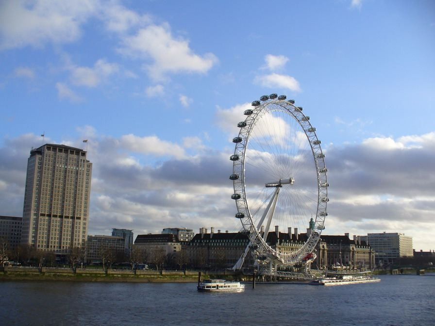 Shell: Tower and observation wheel on the far bank of the river under a blue sky