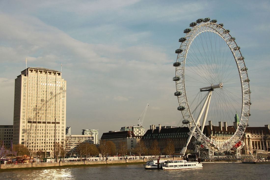 Shell: Tower beside the observation wheel and riverside buildings, with a tour boat on the river