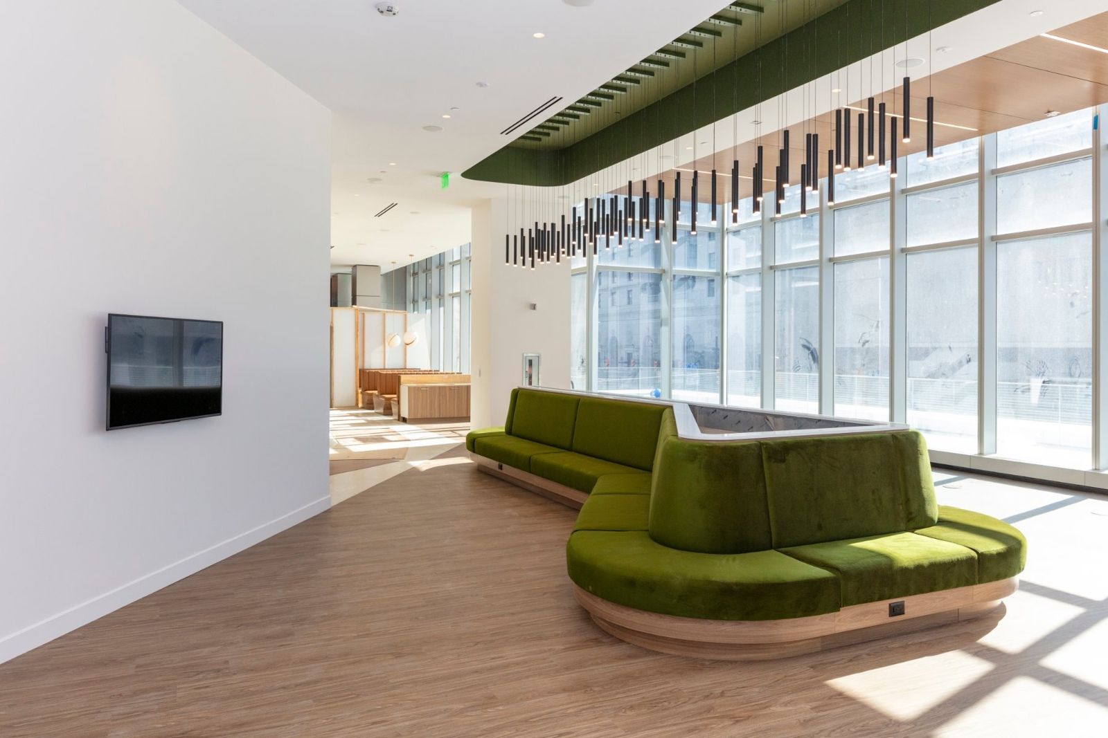 Sherwin-Williams: Curved green sofa below a hanging light installation