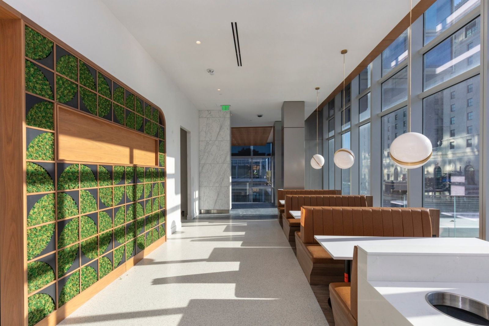 Sherwin-Williams: Dining area with a living green wall and pendant lights