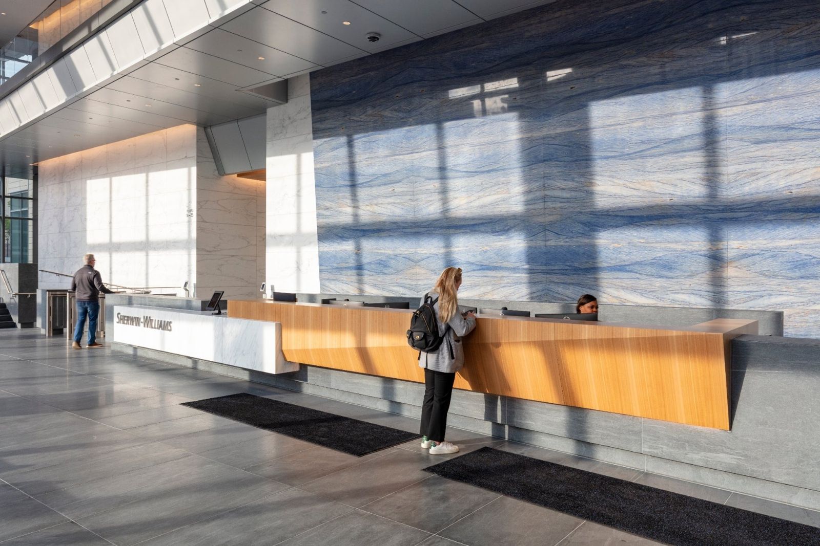 Sherwin-Williams: Long reception desk in front of a blue stone wall