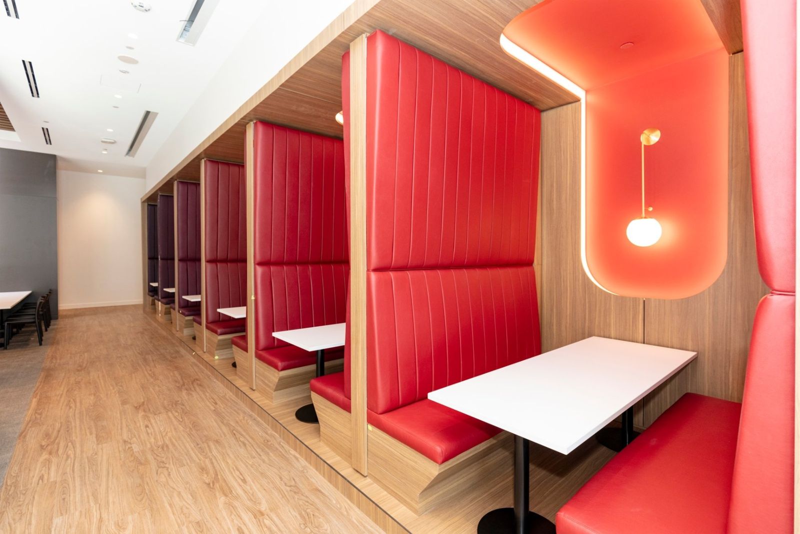 Sherwin-Williams: Red upholstered booths with lamps in curved niches
