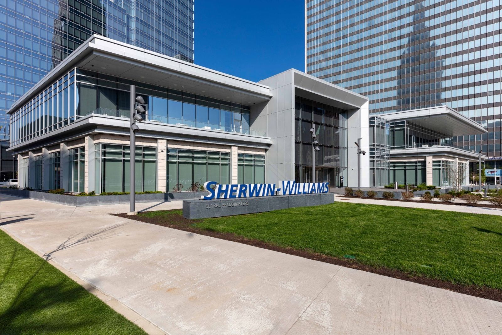 Sherwin-Williams: Two-story glass pavilion with a Sherwin-Williams sign on a lawn