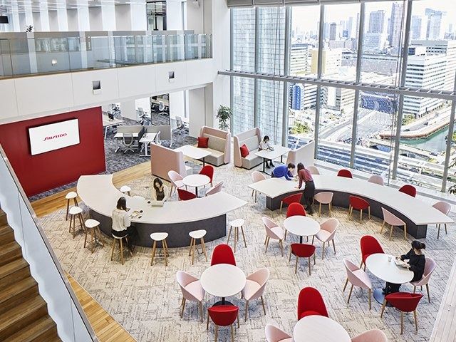 Shiseido: Bright space with white and red seating and a long table