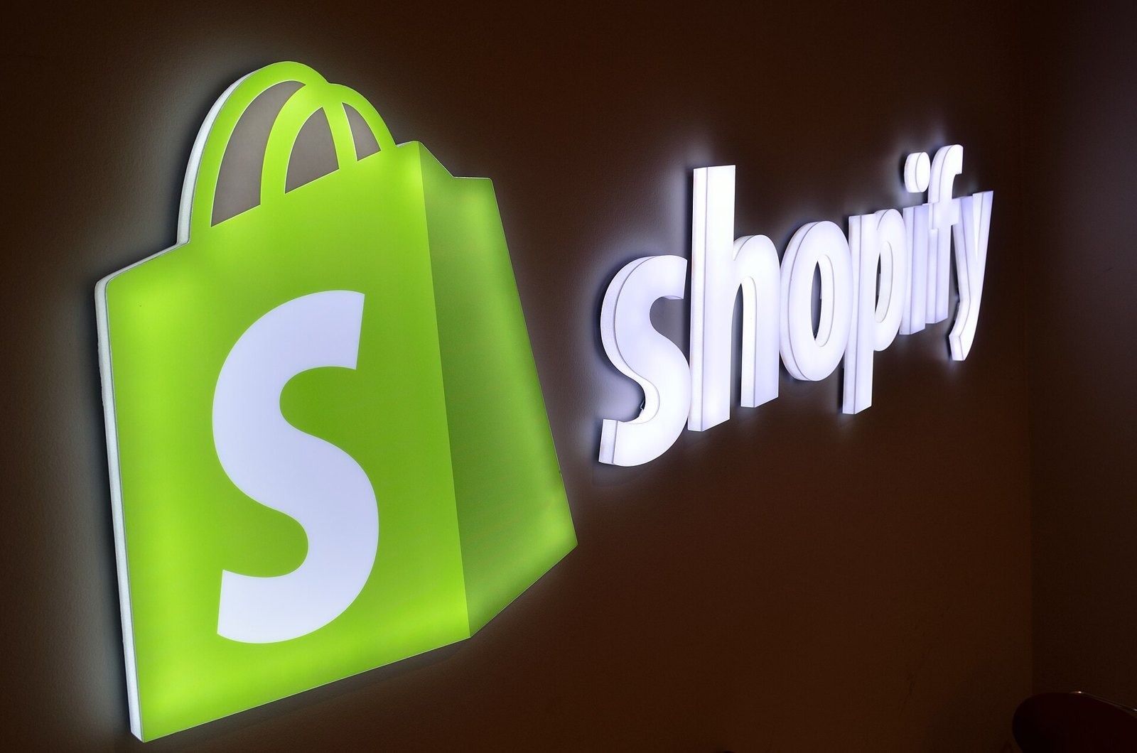 Shopify: A lit Shopify logo in an office