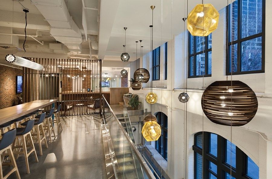 Shopify: A long bar with glowing pendant lamps in a heritage hall, Shopify Montréal