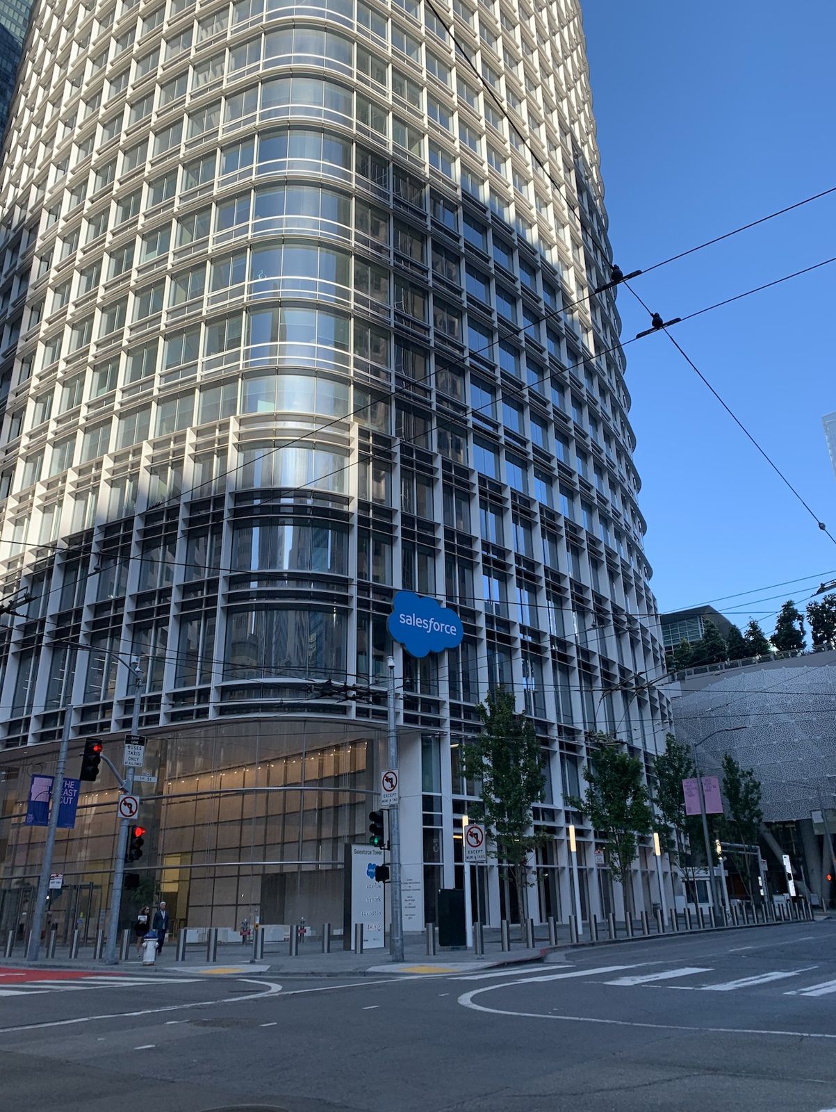 Slack: Base of the tower with a curved glass curtain wall at a street corner