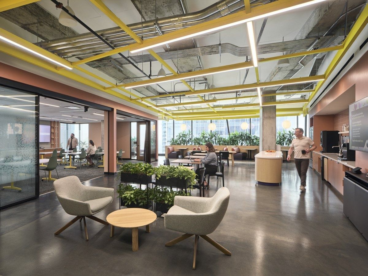 Snap: A lounge with armchairs and planters under yellow beams