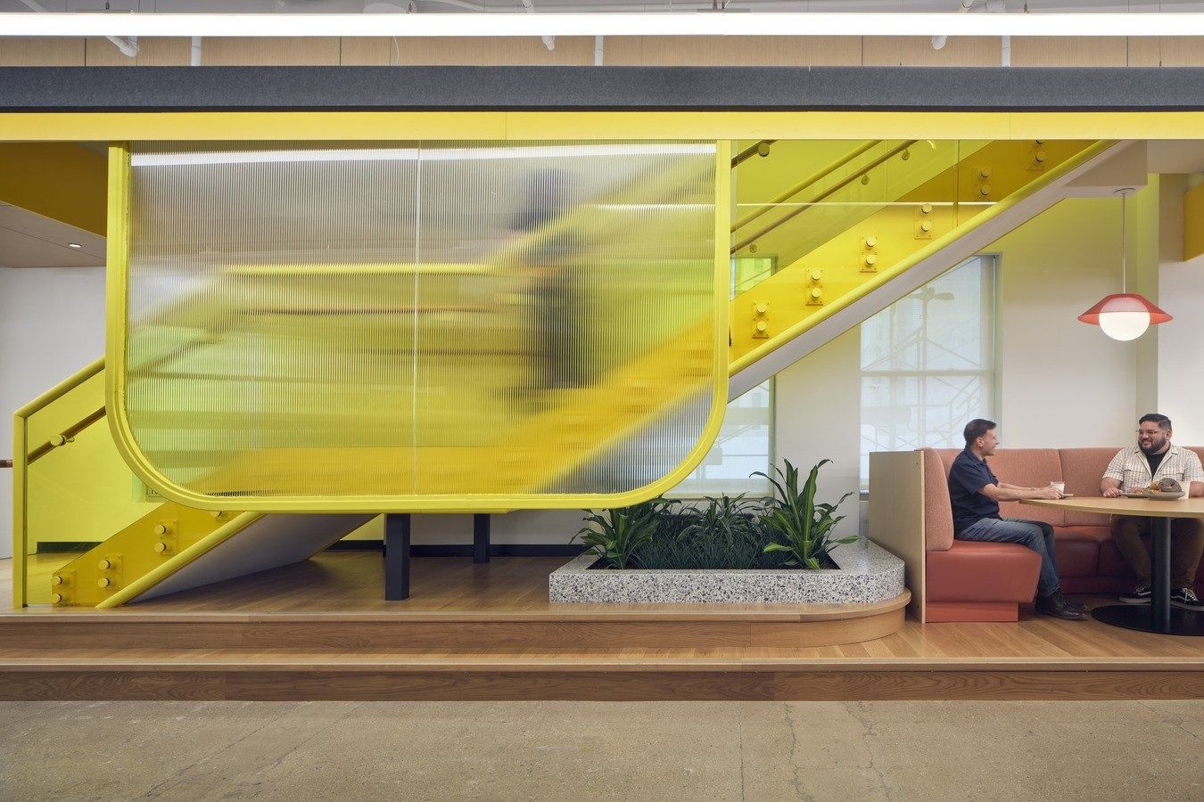 Snap: A yellow stair behind ribbed glass above a booth