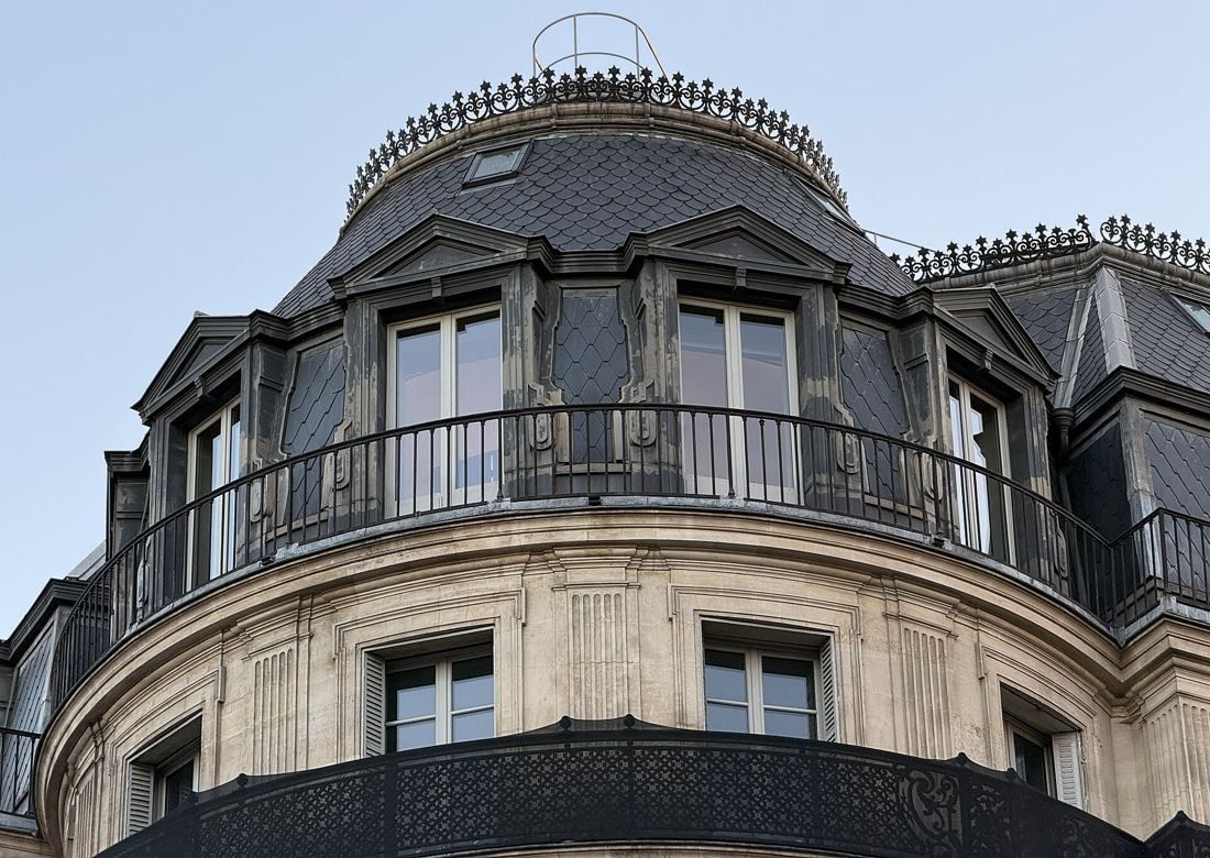 Société Générale: Close view of a slate-covered dome with dormer windows and an iron balcony