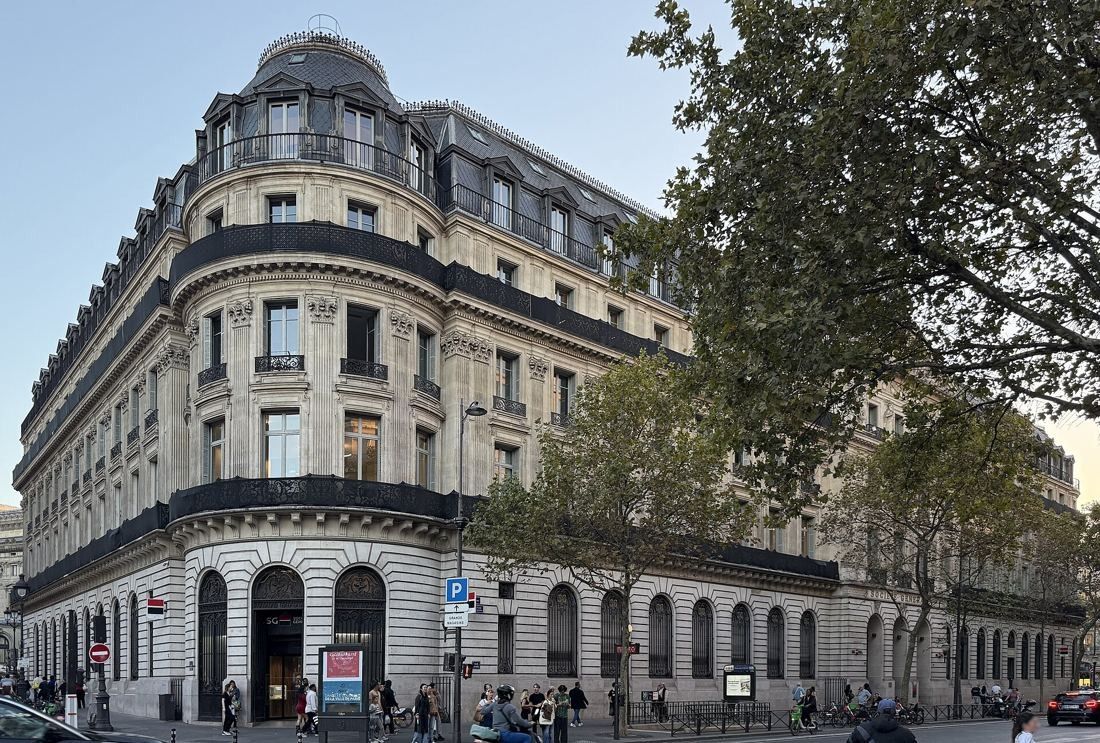 Société Générale: Corner of a Haussmann-era stone building with a round domed tower, trees along the pavement