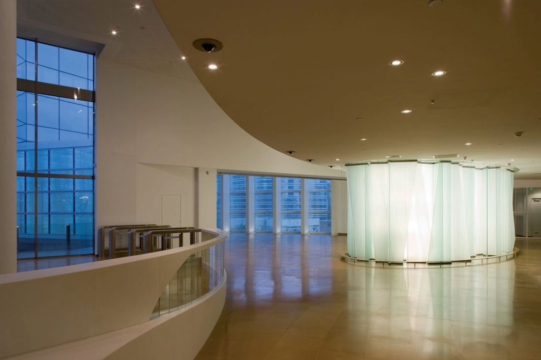 Société Générale: Curved white lobby with a glossy floor, tall windows and a glowing translucent glass wall