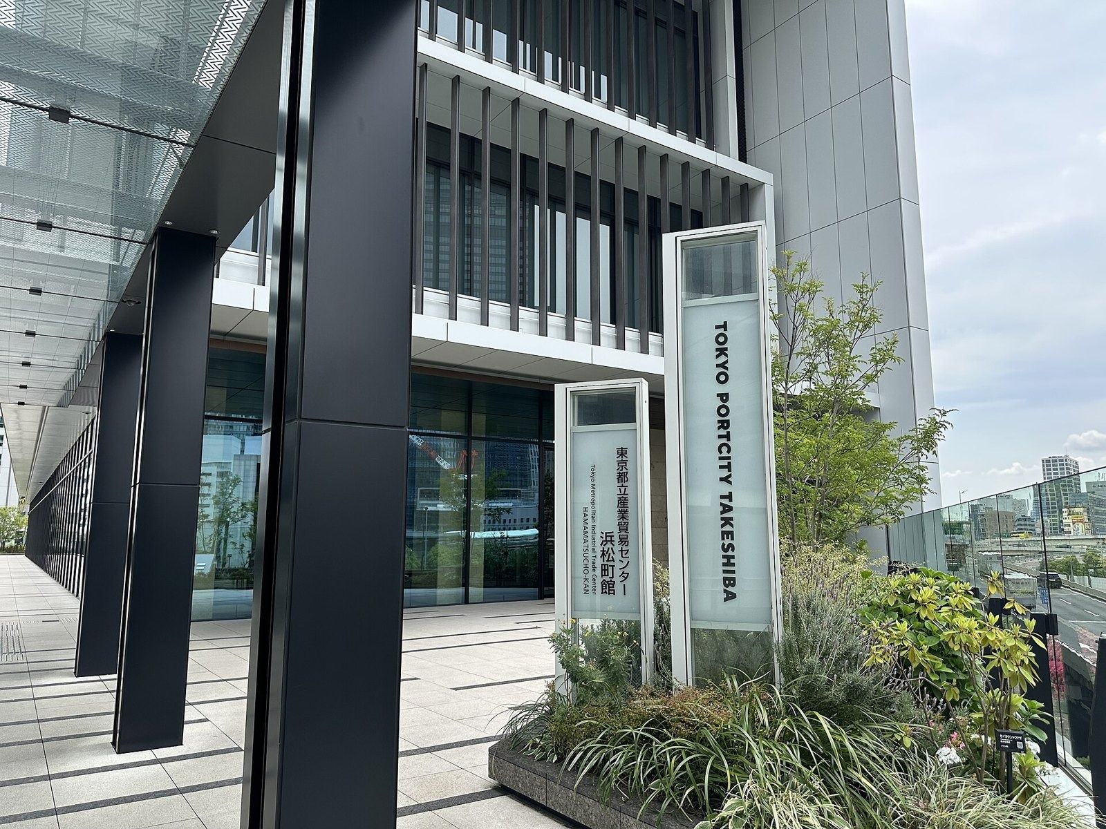 SoftBank Group: Building entrance with a tall sign reading Tokyo Portcity Takeshiba