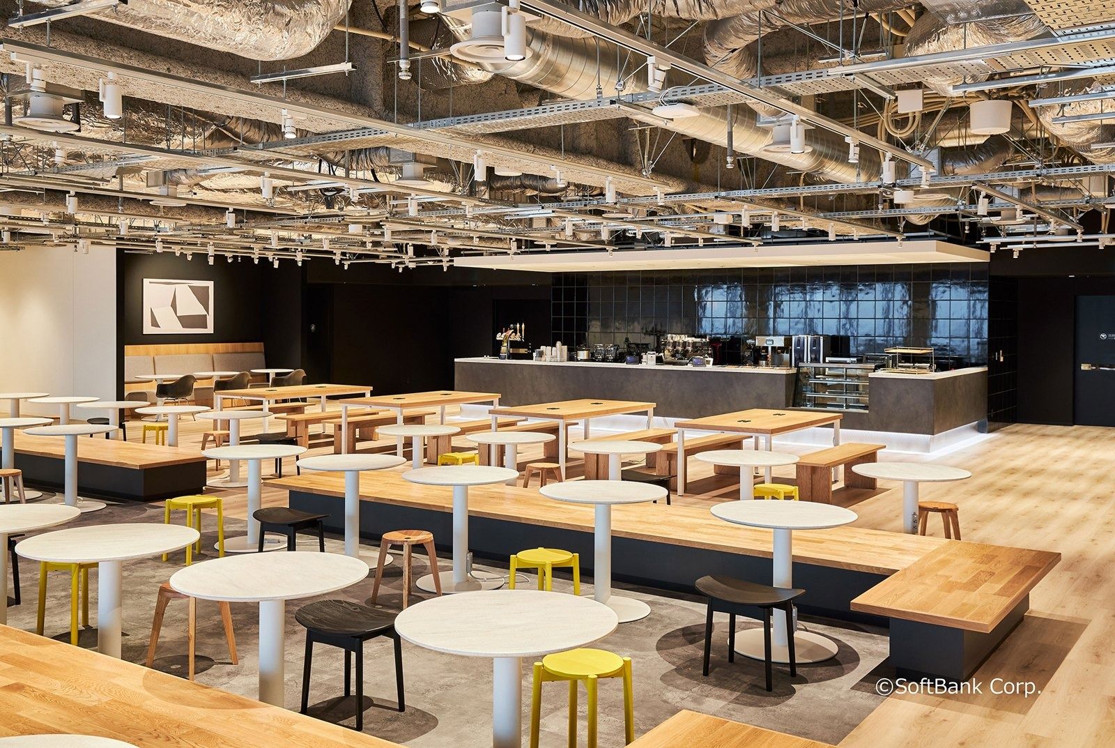 SoftBank Group: Cafeteria with wooden benches, round tables and a serving counter