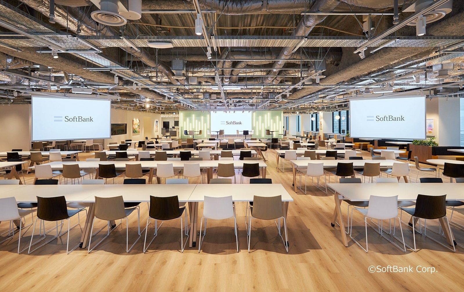 SoftBank Group: Large cafeteria with rows of white tables and screens