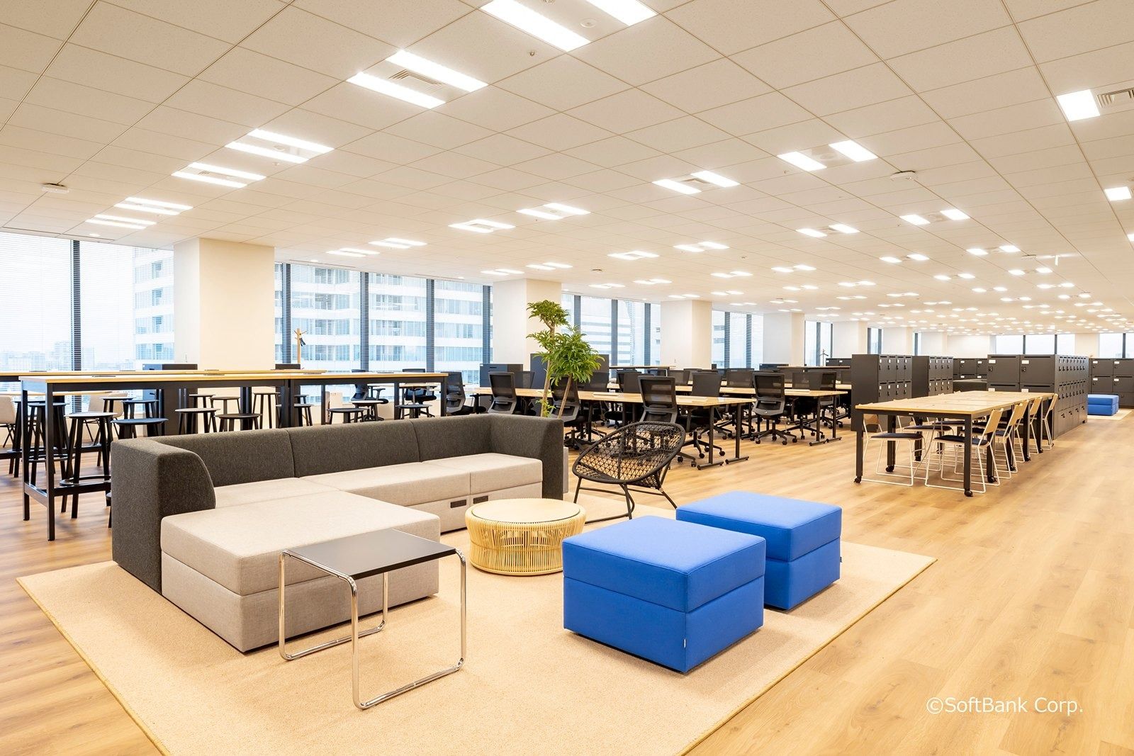 SoftBank Group: Open work floor with sofas, blue ottomans and long desks
