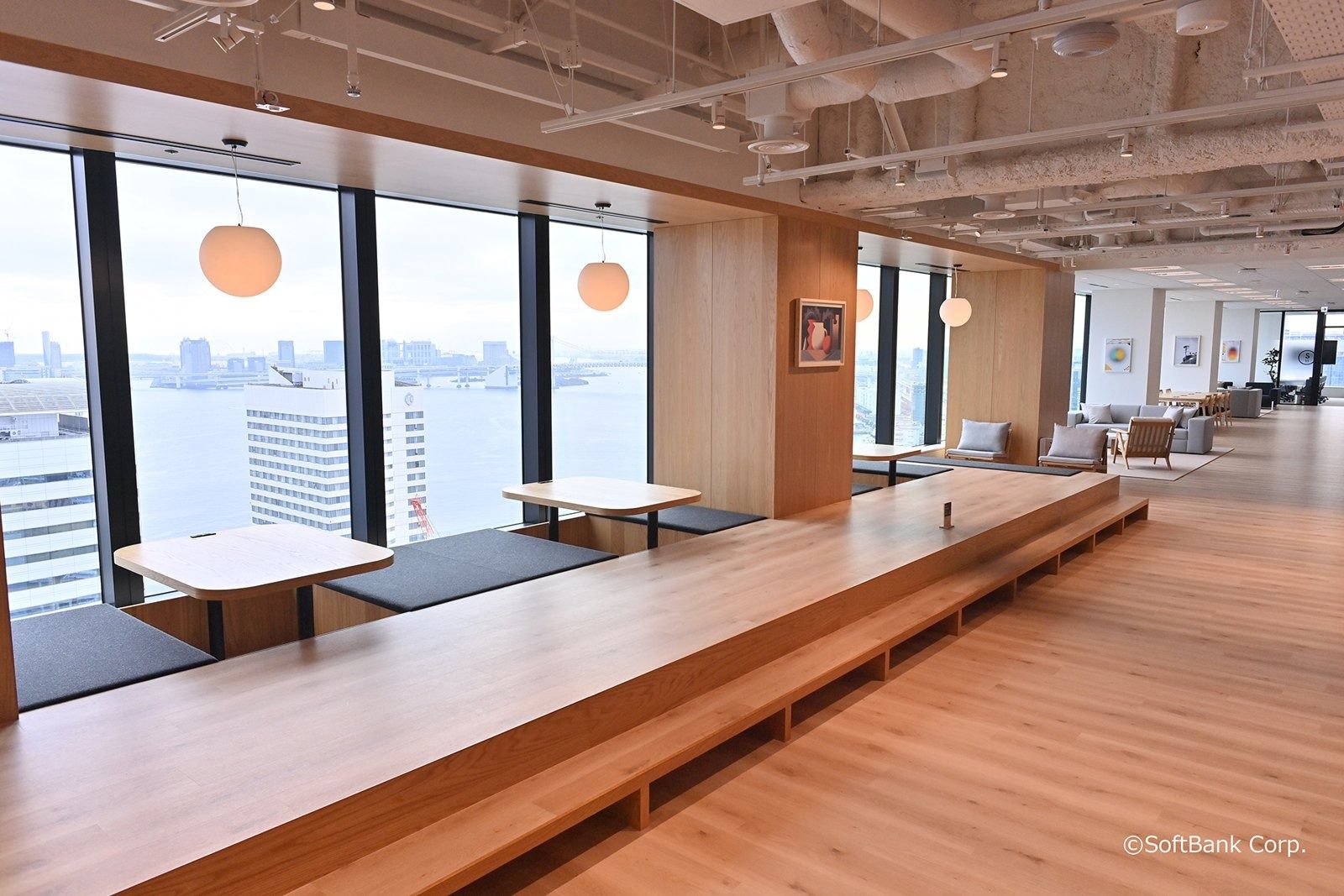 SoftBank Group: Raised wooden platform with low tables by the windows
