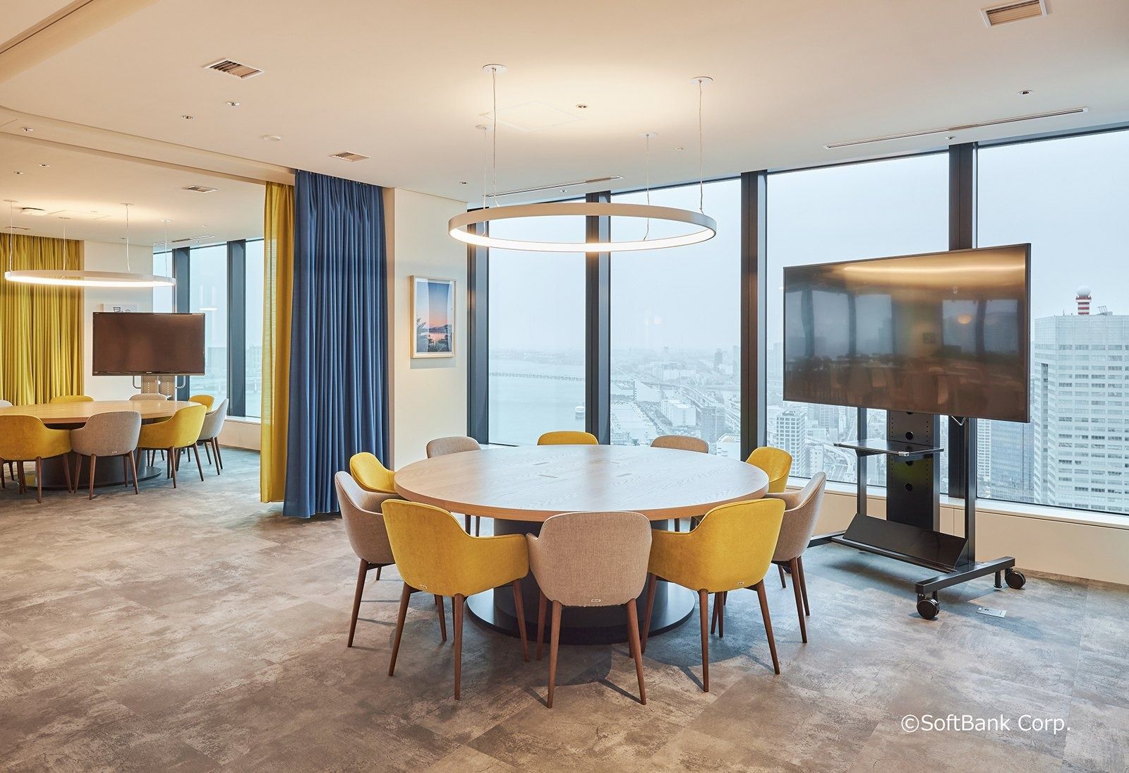 SoftBank Group: Round meeting table with yellow chairs and blue curtains