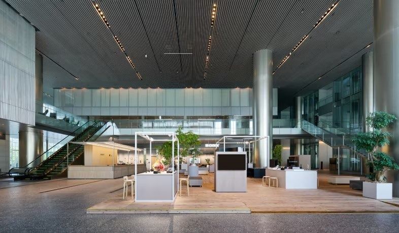 Sony Group: A vast open atrium floor with plants and escalators