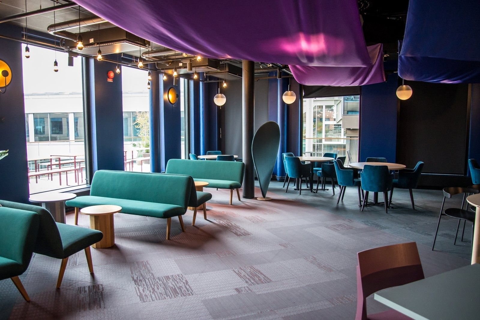 Spotify: A café with teal sofas under purple fabric