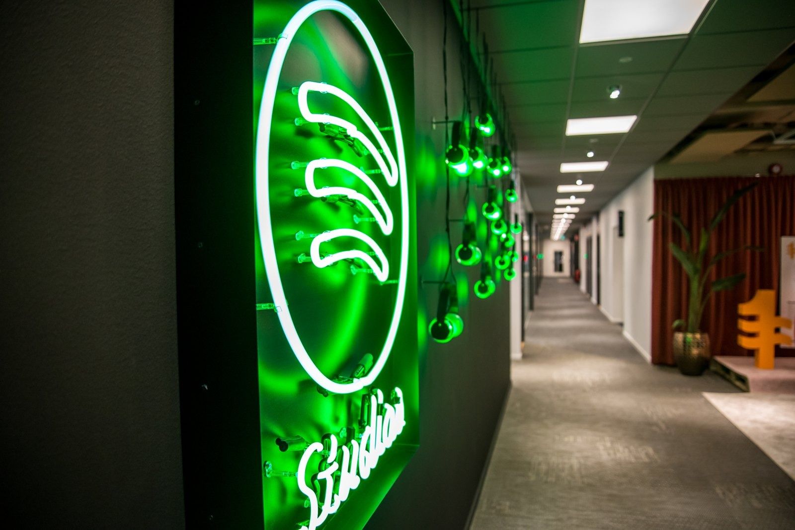 Spotify: A green neon Spotify logo in a corridor