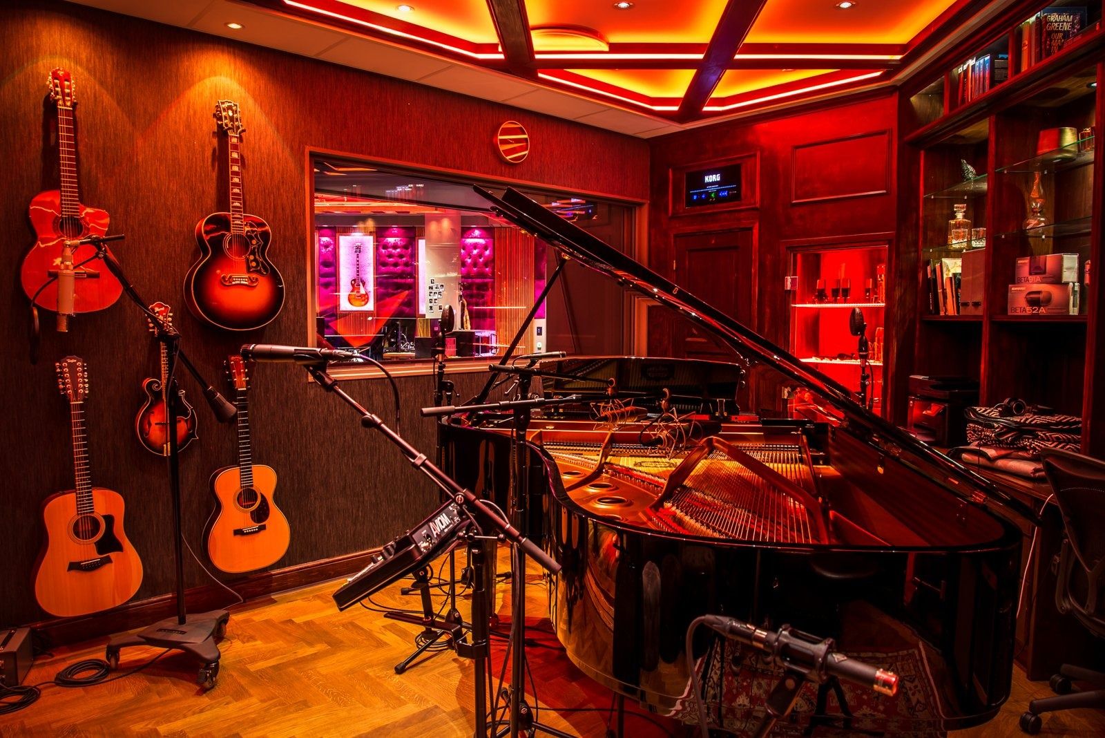 Spotify: A recording studio with a grand piano and guitars under red light